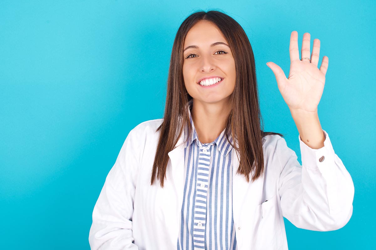 MODEL showing and pointing up with fingers number five while smiling confident and happy.