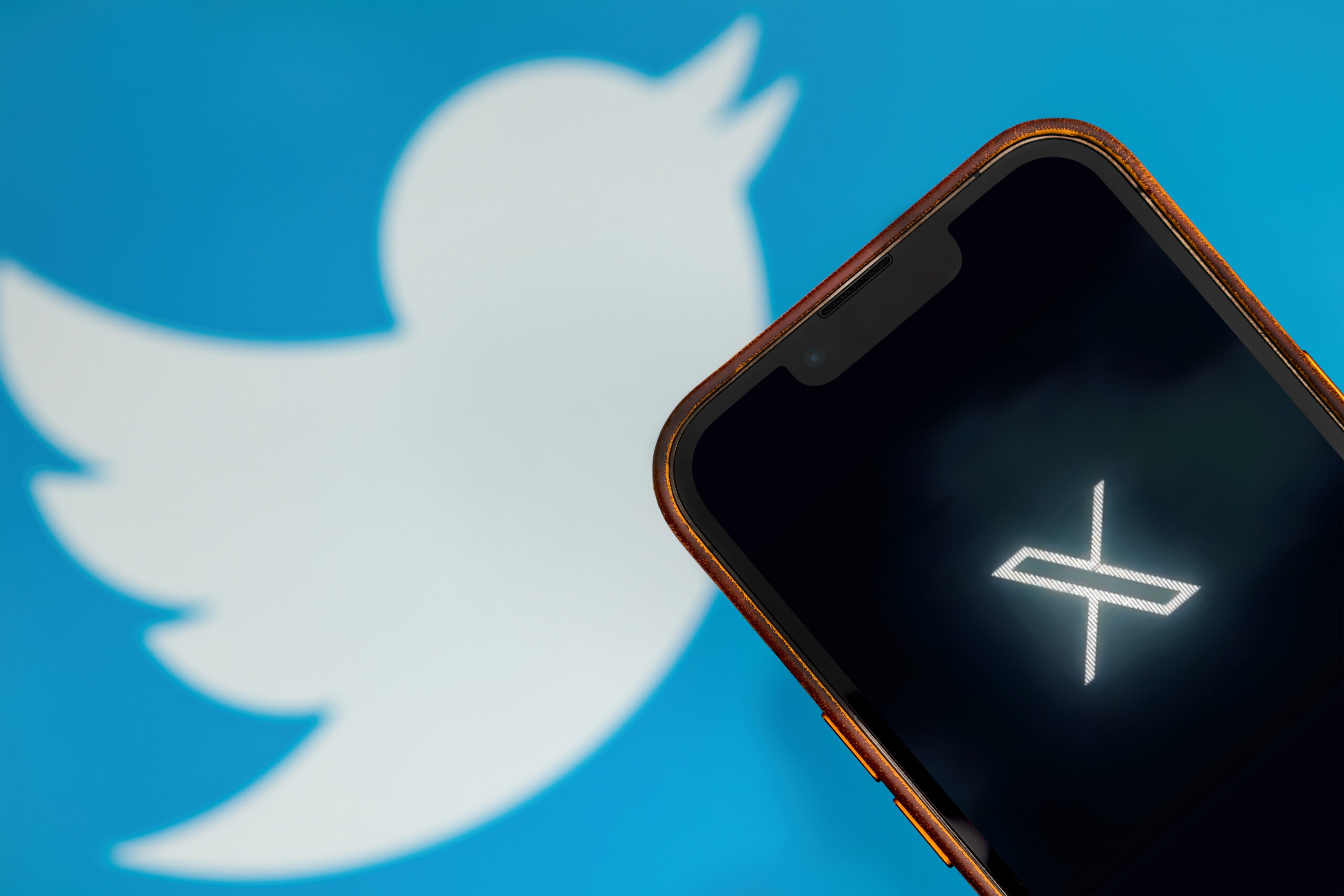 Antalya, Turkey - July 24, 2023: Twitter X logo on smartphone and Twitter logo in background