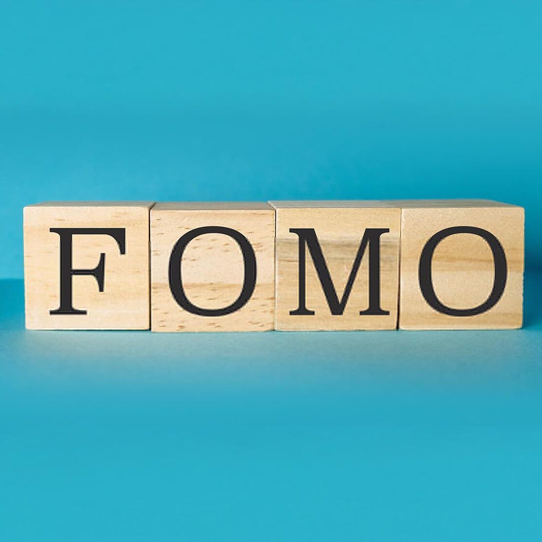 Wooden block with the letters FOMO written on it. The block is arranged in a way that it looks like a word. Concept of simplicity and minimalism